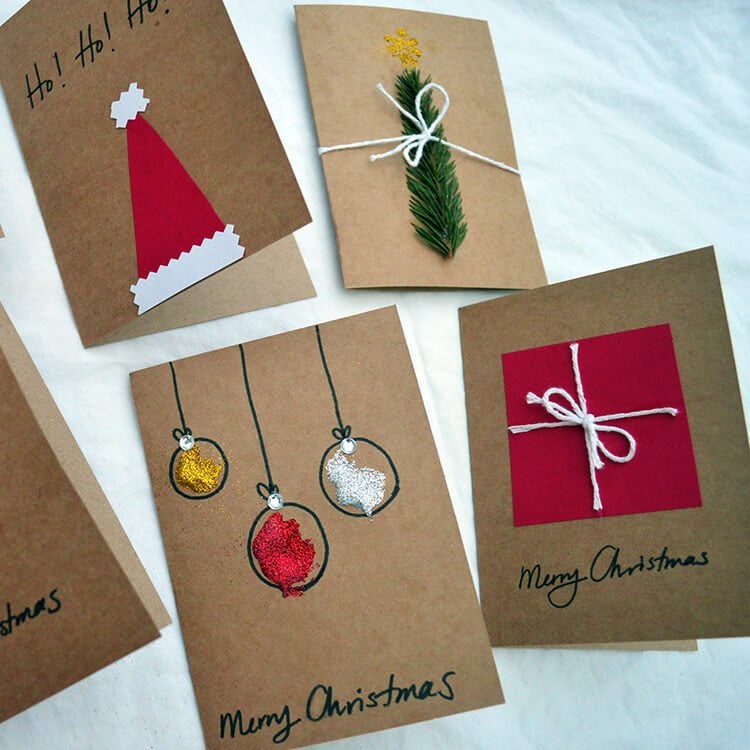 Handmade Christmas cards made using Kraft paper, string, gilitter, and greenery.