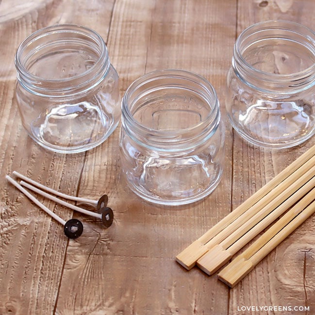 Three small canning jars sit on a table with three tabbed wicks and three unbroken chopsticks.