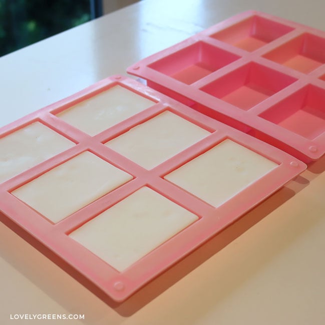 Two of the same 6-cavity soap molds. One is filled with six bars of white soap while the other is empty.