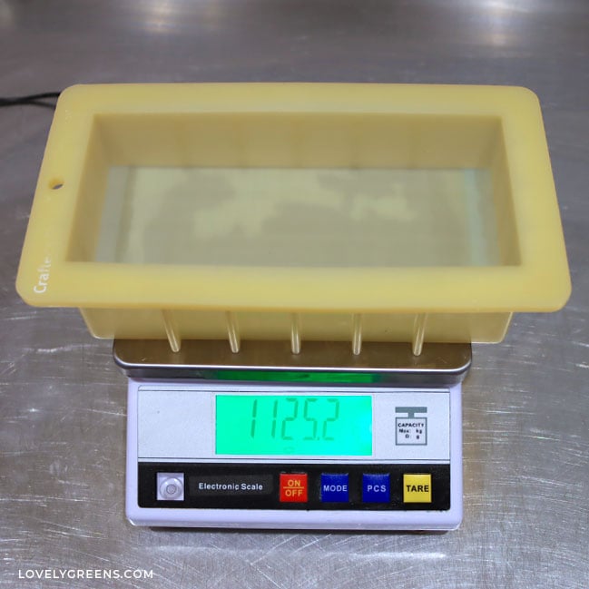 A silicone loaf mold sits on a large digital scale that reads 1125.2 grams.